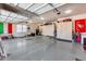 Organized garage with car cover, epoxy flooring, storage cabinets, and plenty of space for vehicles at 8024 W Vista Ave, Glendale, AZ 85303