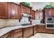 Gourmet kitchen features granite countertops, stainless steel appliances and stylish dark wood cabinetry at 8024 W Vista Ave, Glendale, AZ 85303