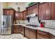 Gourmet kitchen features granite countertops, stainless steel appliances and stylish dark wood cabinetry at 8024 W Vista Ave, Glendale, AZ 85303