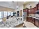 Modern kitchen boasts stainless steel appliances, granite countertops, and seamless flow to the living and dining areas at 8024 W Vista Ave, Glendale, AZ 85303