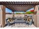 Inviting patio with a wooden pergola, stylish furniture, and an outdoor kitchen area at 8024 W Vista Ave, Glendale, AZ 85303