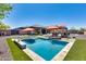 Sparkling pool and patio area with outdoor kitchen, BBQ, lounge chairs and shade umbrellas at 8024 W Vista Ave, Glendale, AZ 85303