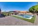 Expansive backyard showcasing a pool with a lounge area, outdoor kitchen, and desert landscaping at 8024 W Vista Ave, Glendale, AZ 85303