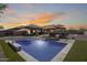 Backyard pool with outdoor kitchen, bar seating and umbrellas create a perfect entertaining space at 8024 W Vista Ave, Glendale, AZ 85303