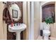 Charming powder room with stylish vessel sink, decorative mirror, and unique tiled wall feature at 8024 W Vista Ave, Glendale, AZ 85303