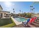 Backyard featuring an outdoor kitchen, a pool, a hot tub, cactus landscaping, palm trees, and plenty of seating at 8730 E Montecito Ave, Scottsdale, AZ 85251