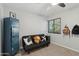 This bedroom features a black futon sofa, soft gray walls, ceiling fan, window, and a blue shelving unit at 8730 E Montecito Ave, Scottsdale, AZ 85251