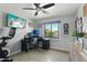 A bright bedroom with a desk, dual monitors, tile flooring, and a large window with neighborhood views at 8730 E Montecito Ave, Scottsdale, AZ 85251