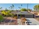 Single-story home with tidy desert landscaping, a brick walkway, and a modern gray garage door at 8730 E Montecito Ave, Scottsdale, AZ 85251
