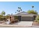 Charming single-story home with desert landscaping, palm trees, and a modern dark gray two-car garage at 8730 E Montecito Ave, Scottsdale, AZ 85251