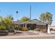 Charming single-story home with desert landscaping, palm trees, and a modern dark gray two-car garage at 8730 E Montecito Ave, Scottsdale, AZ 85251