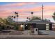 Charming single-story home with desert landscaping, palm trees, and a modern dark gray two-car garage at 8730 E Montecito Ave, Scottsdale, AZ 85251