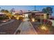 Inviting home exterior with a stone walkway, desert landscaping, and warm exterior lighting at 8730 E Montecito Ave, Scottsdale, AZ 85251