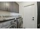 Practical laundry room with granite countertops and overhead cabinets at 8730 E Montecito Ave, Scottsdale, AZ 85251
