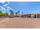 Spacious gravel backyard with storage sheds and a covered patio at 930 E Friar Ave, Apache Junction, AZ 85119