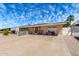 Single-story home with a front yard, driveway, and a red motorcycle parked outside at 930 E Friar Ave, Apache Junction, AZ 85119