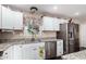 Well-lit kitchen with stainless steel appliances, granite counters and white cabinets at 930 E Friar Ave, Apache Junction, AZ 85119