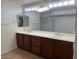 A bathroom featuring a double vanity with a large mirror, ample cabinet space, and stylish fixtures at 9556 W Blue Sky Dr, Peoria, AZ 85383