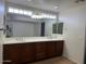 Bathroom featuring a double vanity with a large mirror, ample cabinet space, and stylish fixtures at 9556 W Blue Sky Dr, Peoria, AZ 85383