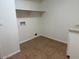 Functional laundry room features a shelf, electric outlets, and neutral tile flooring at 9556 W Blue Sky Dr, Peoria, AZ 85383