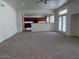 Open living room with carpet overlooking kitchen with dark wood cabinets at 9556 W Blue Sky Dr, Peoria, AZ 85383