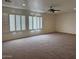 Expansive living area featuring plush carpet, ceiling fan, and shuttered windows at 9556 W Blue Sky Dr, Peoria, AZ 85383
