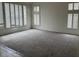 Spacious living room with neutral carpet and large windows with white shutters at 9556 W Blue Sky Dr, Peoria, AZ 85383