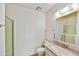 Well-lit bathroom featuring a pink vanity and shower with glass door at 9635 W Ironwood Dr # B, Peoria, AZ 85345