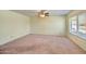 Spacious room featuring a ceiling fan, a large window, and neutral paint at 9635 W Ironwood Dr # B, Peoria, AZ 85345