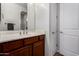 Bathroom showcasing a wooden vanity with white countertops, complemented by a large mirror and white walls at 10040 E Grandview St, Mesa, AZ 85207