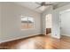 Bedroom featuring hardwood floors, chandelier, large window, and bathroom access at 10040 E Grandview St, Mesa, AZ 85207
