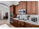 Well-lit kitchen boasts stainless steel appliances, cooktop, white countertops, and dark wood cabinetry at 10040 E Grandview St, Mesa, AZ 85207