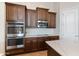 Modern kitchen boasting stainless steel double oven and microwave combo, and dark cabinetry at 10040 E Grandview St, Mesa, AZ 85207