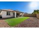 Expansive backyard featuring artificial grass, desert rock landscaping, and a covered patio, perfect for outdoor enjoyment at 10714 E Lincoln Ave, Mesa, AZ 85212