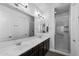 Bright bathroom featuring dual sinks, dark cabinets, and a glass-enclosed shower, blending style and functionality at 10714 E Lincoln Ave, Mesa, AZ 85212