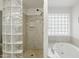 The bathroom has a stand-up shower with glass block window and a soaking tub at 11059 E Kilarea Ave, Mesa, AZ 85209