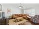 Cozy living room features a comfortable sectional sofa, ceiling fan, and natural light at 11059 E Kilarea Ave, Mesa, AZ 85209