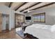Bedroom displays a large window, ceiling beams, a sofa, and light hardwood floors at 11123 E Monument Dr, Scottsdale, AZ 85262