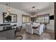 Bright dining room with a wooden table, white chairs, and large windows with plantation shutters at 11123 E Monument Dr, Scottsdale, AZ 85262