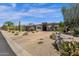Modern home exterior featuring drought-tolerant landscaping, circular driveway, and a neutral color palette at 11123 E Monument Dr, Scottsdale, AZ 85262
