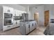 Kitchen featuring stainless appliances, center island with cooktop, and white cabinets at 11123 E Monument Dr, Scottsdale, AZ 85262