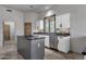Modern kitchen featuring white cabinets, granite countertops, and a central island with a cooktop at 11123 E Monument Dr, Scottsdale, AZ 85262