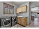 Laundry room with washer, dryer, cabinets, and countertop space, and natural light at 11123 E Monument Dr, Scottsdale, AZ 85262