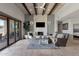 Spacious living room featuring stone floors, a stone fireplace, and high ceilings with wooden beams at 11123 E Monument Dr, Scottsdale, AZ 85262