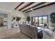 Bright, open living room with stone flooring, beamed ceiling, and seamless access to the outdoor pool and patio at 11123 E Monument Dr, Scottsdale, AZ 85262
