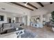 Open-concept living room with stone floors, wooden beams, and a view into the kitchen area at 11123 E Monument Dr, Scottsdale, AZ 85262