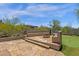 An elegant stone patio features built-in seating with views of the backyard putting green and desert landscaping at 11123 E Monument Dr, Scottsdale, AZ 85262