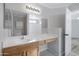 Bright bathroom with vanity, large mirror, and a doorway leading to the bedroom at 12443 W Via Camille --, El Mirage, AZ 85335