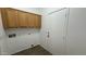 Laundry room showcasing storage cabinets and a white door leading to the exterior at 12505 W Adams St, Avondale, AZ 85323