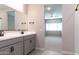 Modern bathroom with double sinks, sleek countertops, and view into an adjacent bedroom at 12547 W Stella Ln, Litchfield Park, AZ 85340